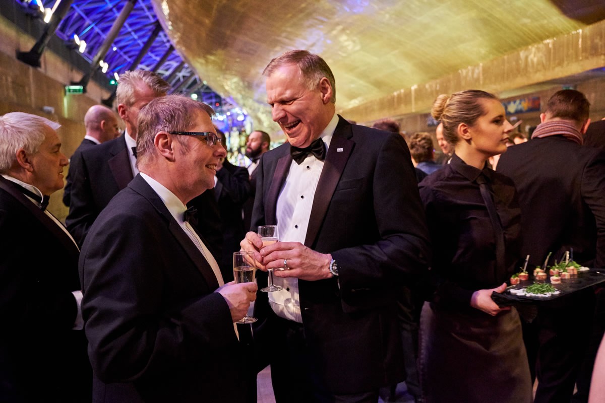 guests talking with the Cutty Sark's hull in the background