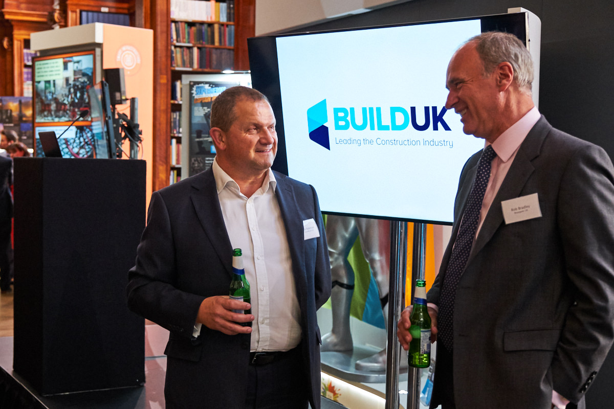 guests talking in front of a Build UK branded screen